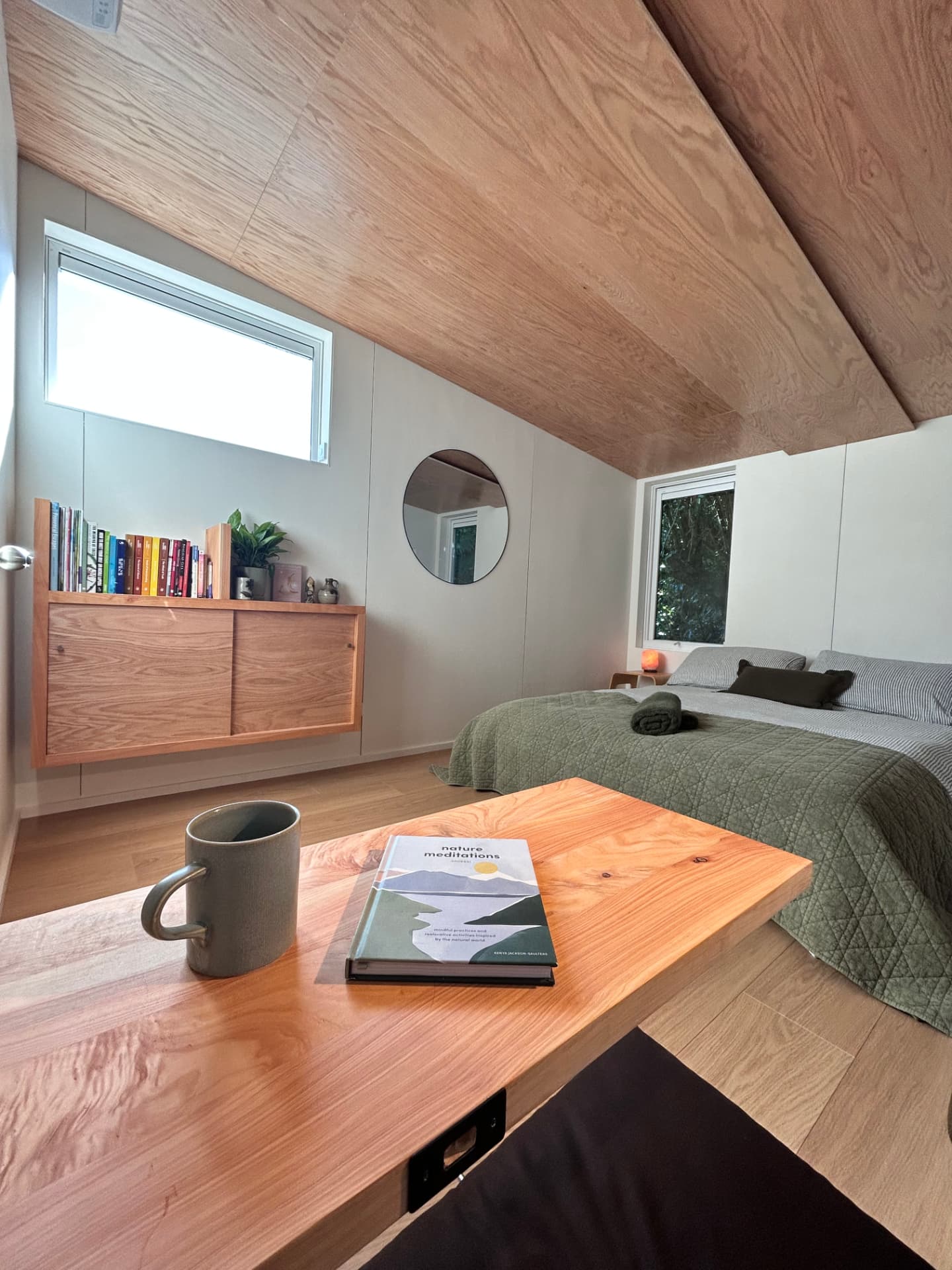 The Pod interior with a reading table and view of the bed